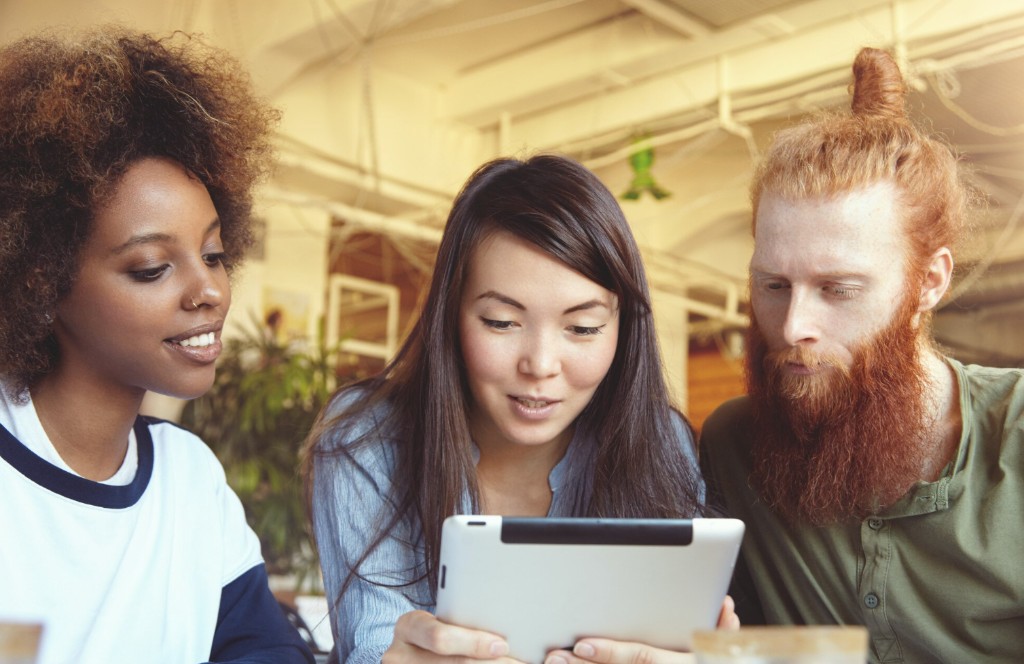 Apprenants engagés autour d’une tablette, collaboration et gamification